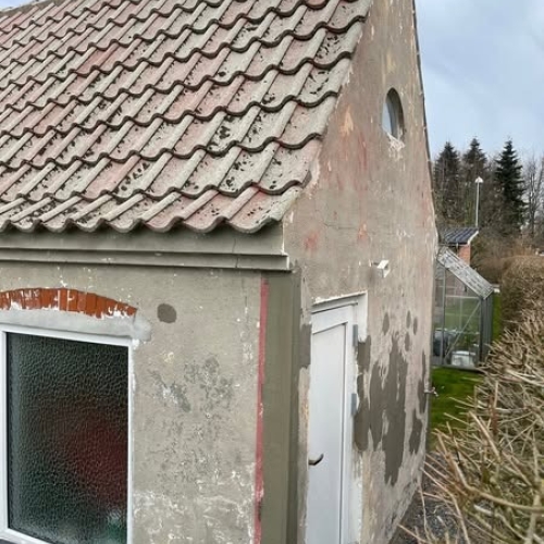 Bygning før facaderenovering – murerarbejde i Sønderjylland med afskallet puds