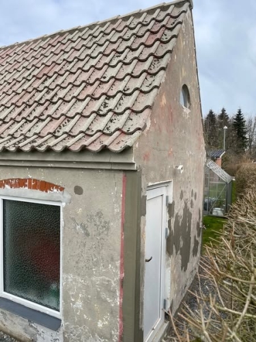 Bygning før facaderenovering – murerarbejde i Sønderjylland med afskallet puds